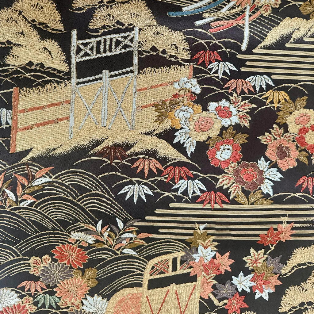 Embroidered fabric with Japanese landscape design featuring a bridge, mountains, and flowers.