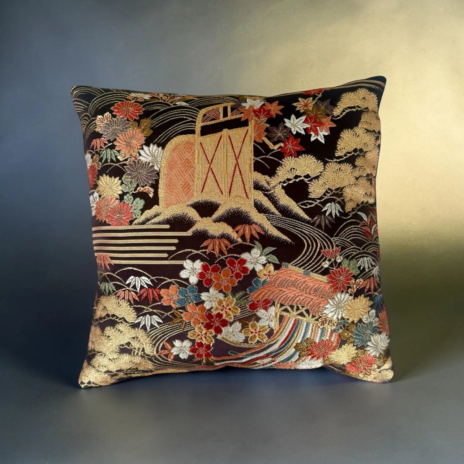 Decorative cushion with intricate floral and nature-themed embroidery on a gradient background