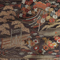 Embroidered fabric with floral patterns and architectural elements on a dark background