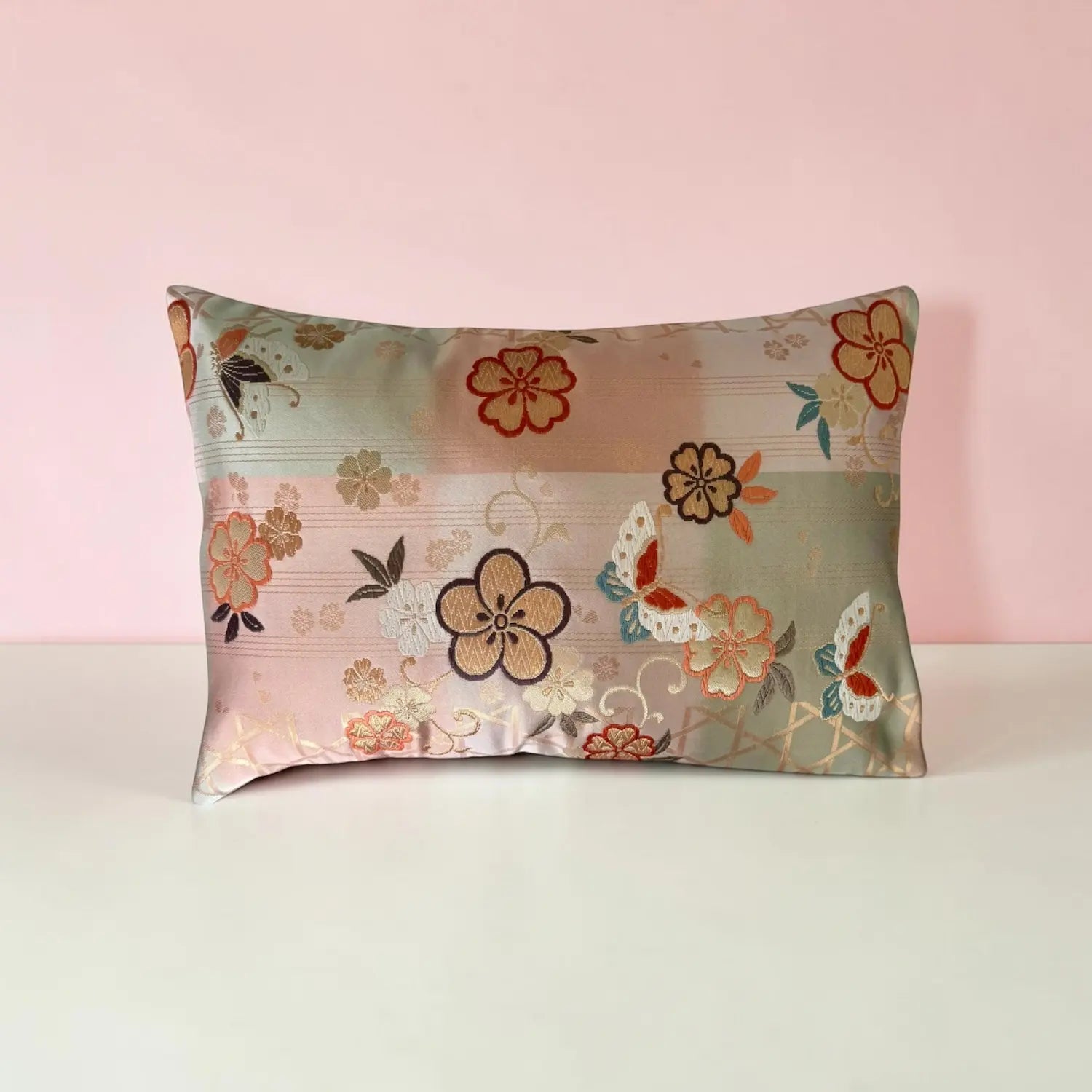 Floral and butterfly patterned cushion on a pink background