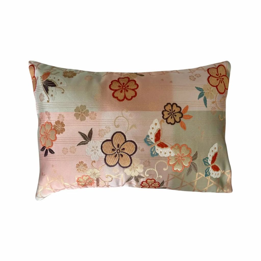 Floral and butterfly patterned cushion on a white background