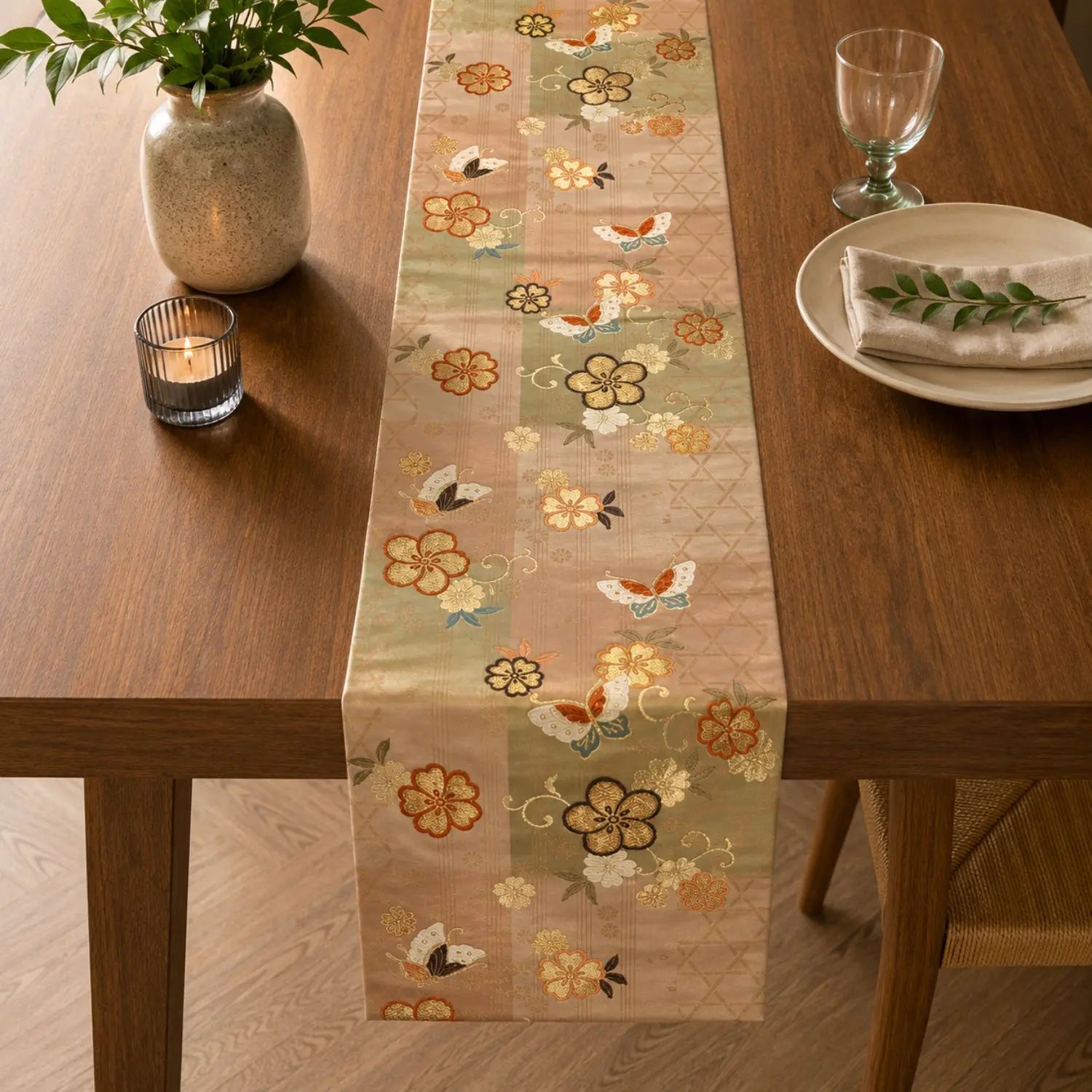 A decorative table runner with a floral and butterfly pattern styled on a wooden dining table