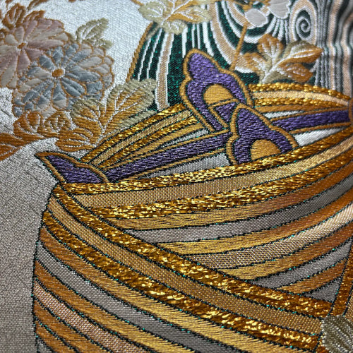 Close-up of intricately embroidered fabric with floral patterns and gold thread.