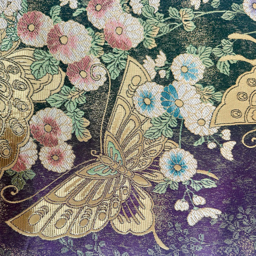 Decorative fabric with embroidered butterflies and flowers on a dark background