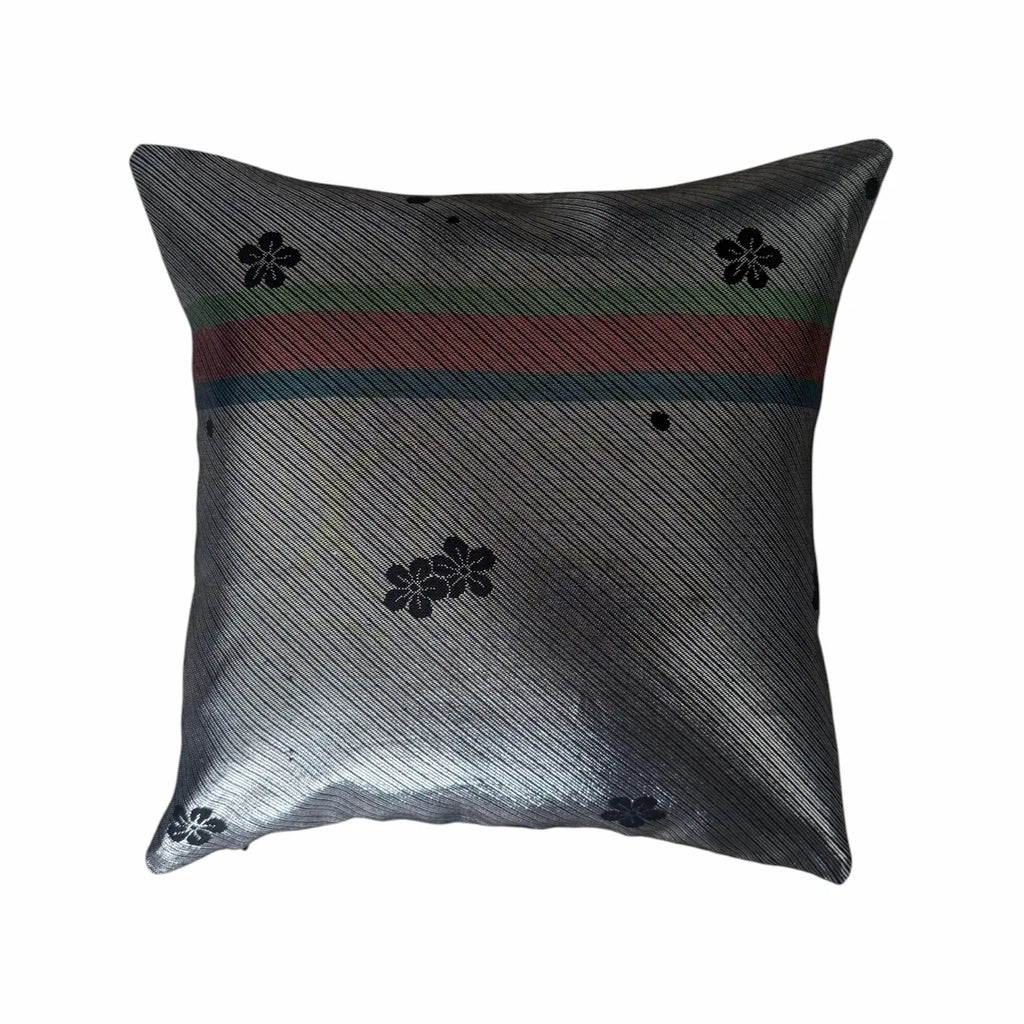 Decorative cushion with black floral patterns and a red and blue stripe on a white background