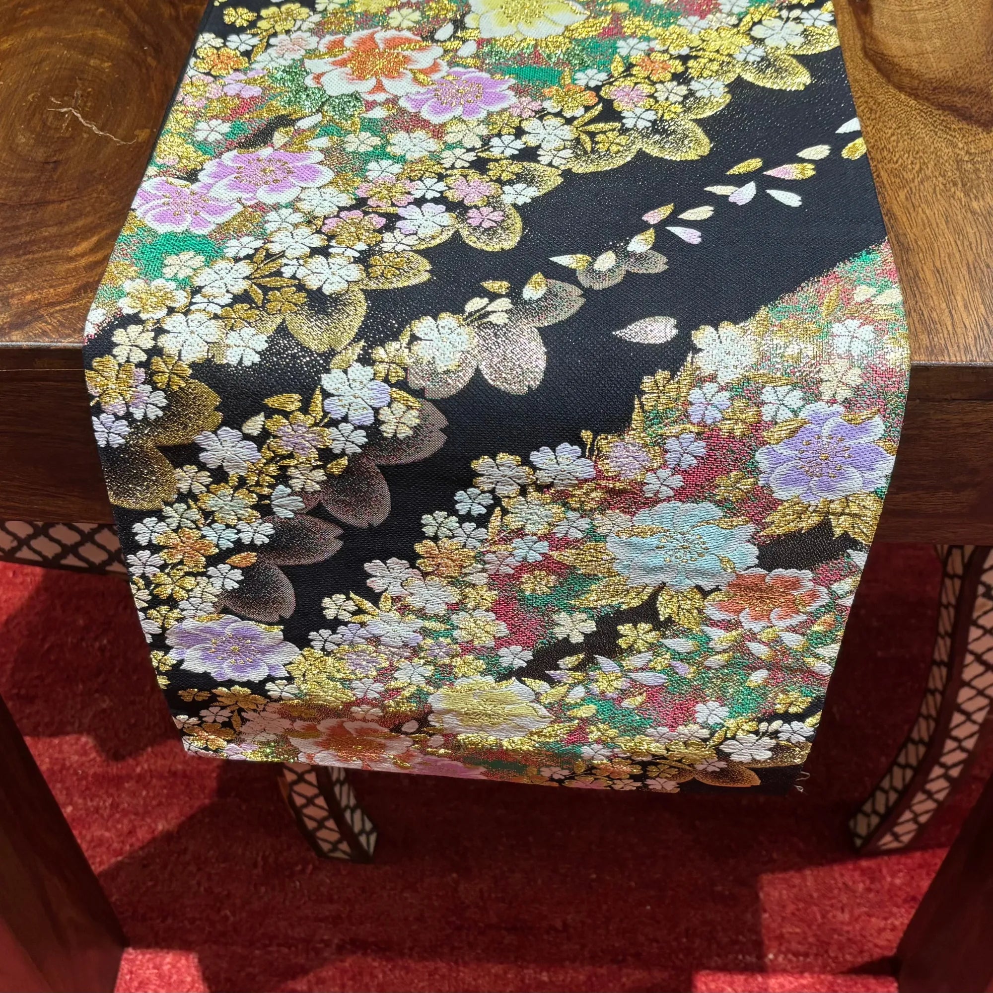 Floral patterned silk table runner on a wooden table
