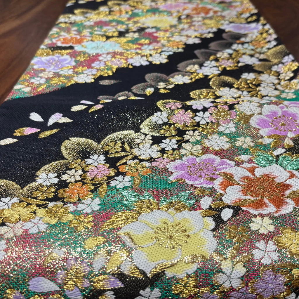 Close-up of a Obi runner with floral patterns and sequins.