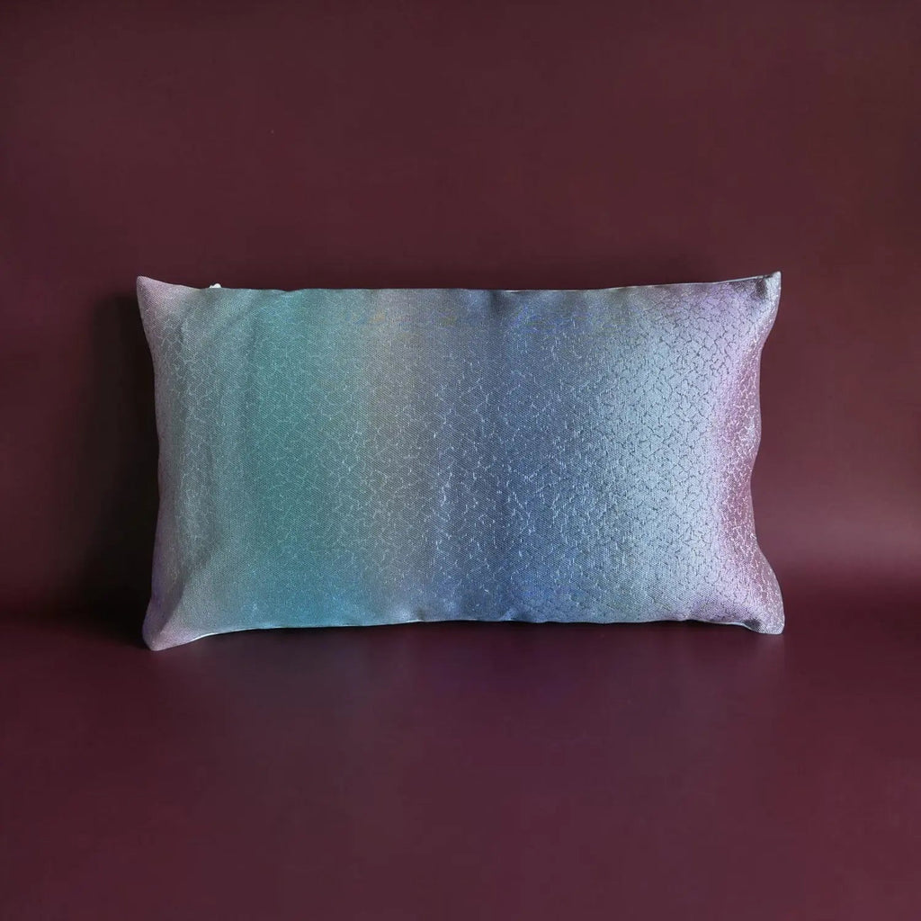 Gradient pillow with purple and blue colors on a dark red background