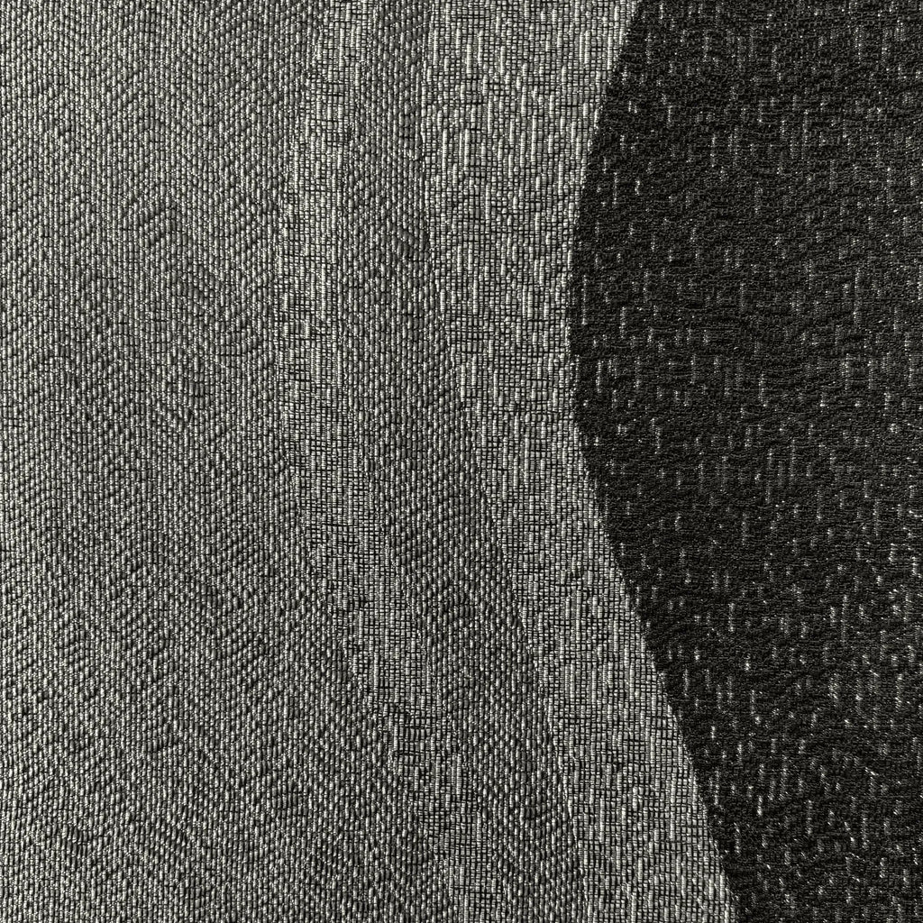 Close-up of a textured fabric with a gradient from gray to black.