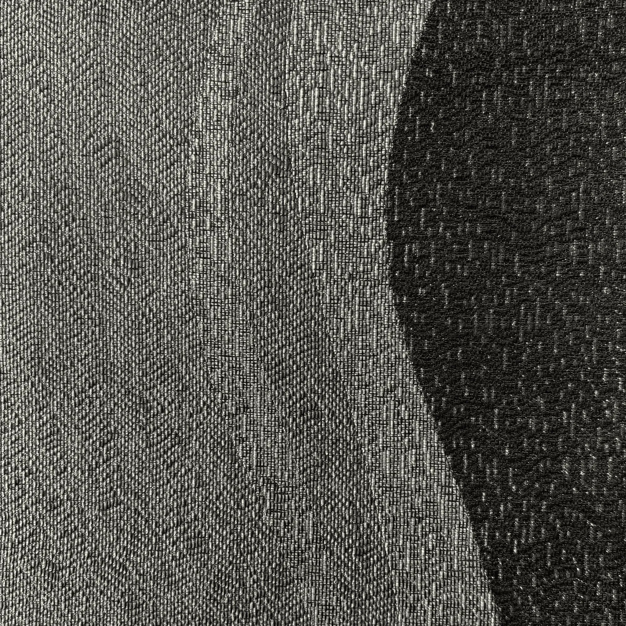 Close-up of a textured fabric with a gradient from gray to black.