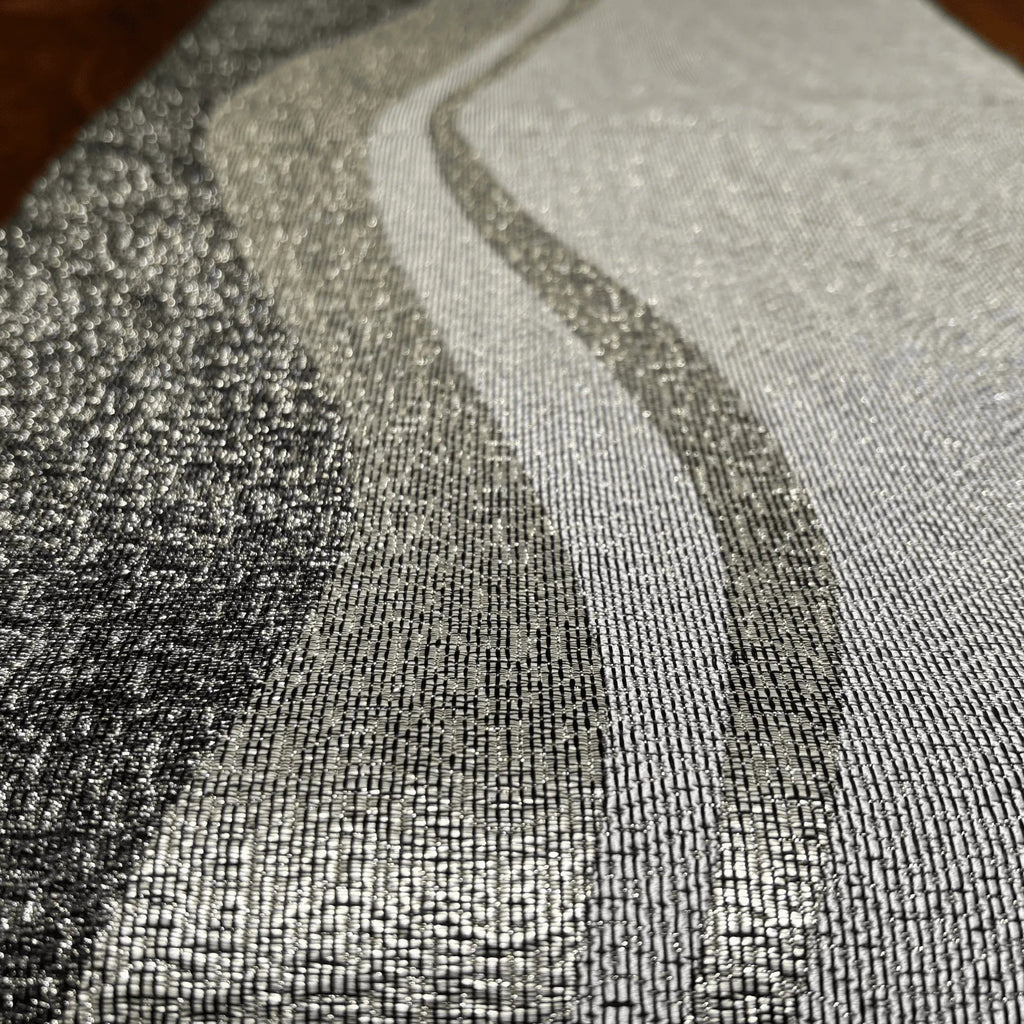 Close-up of textured silver fabric with a wavy pattern