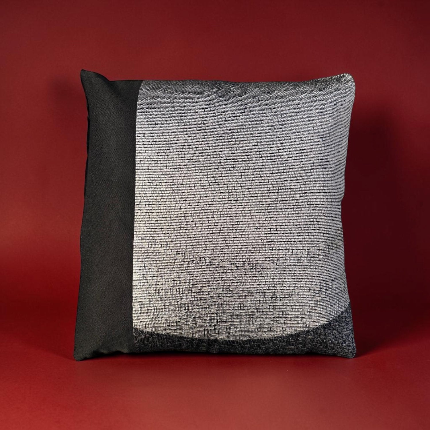 Grey and black cushion on a red background