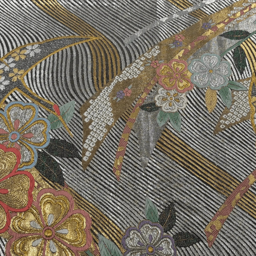 Close-up of an embroidered fabric with floral patterns and geometric shapes.