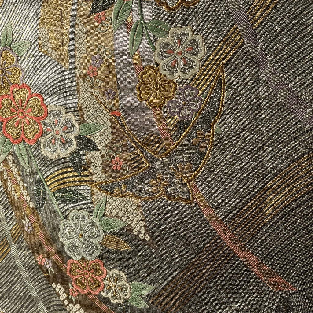 Close-up of an embroidered silk with patterns and a shield design.