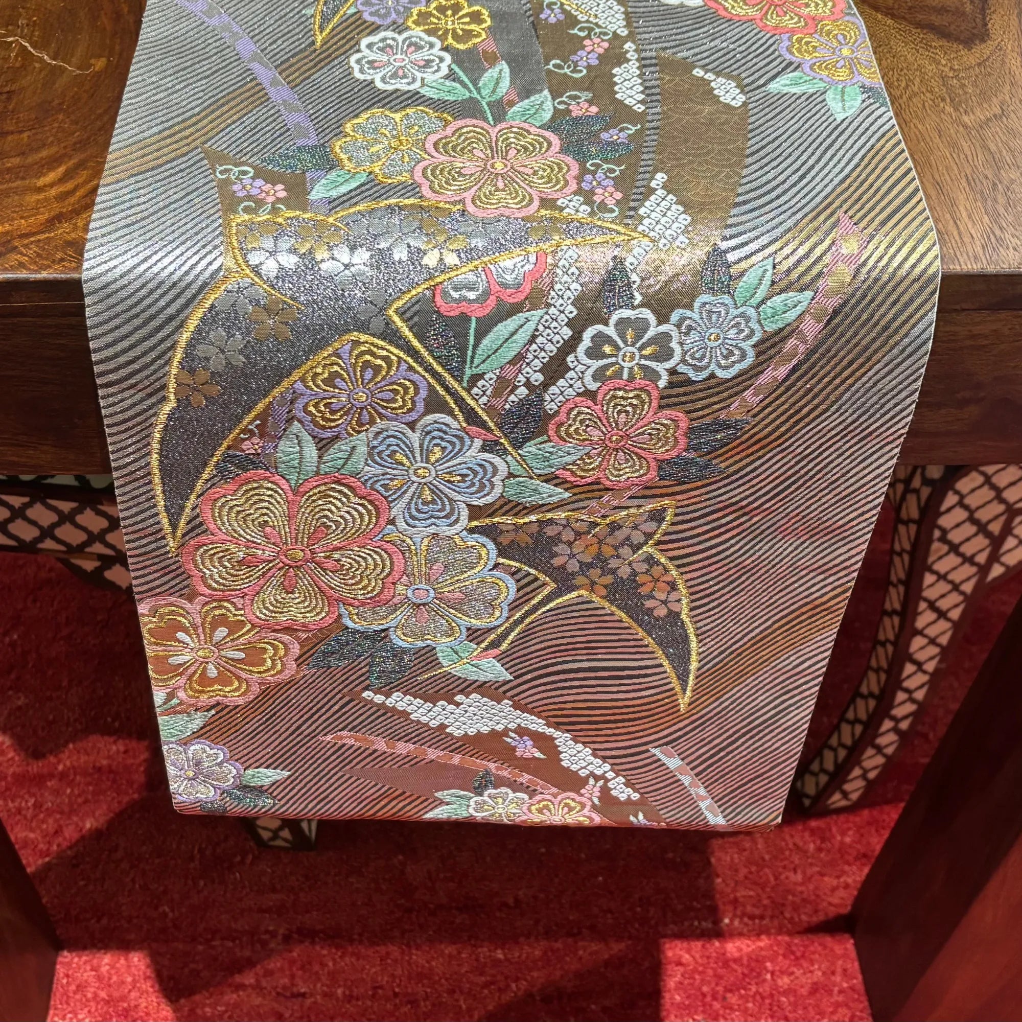 Decorative table runner with floral pattern on a wooden surface