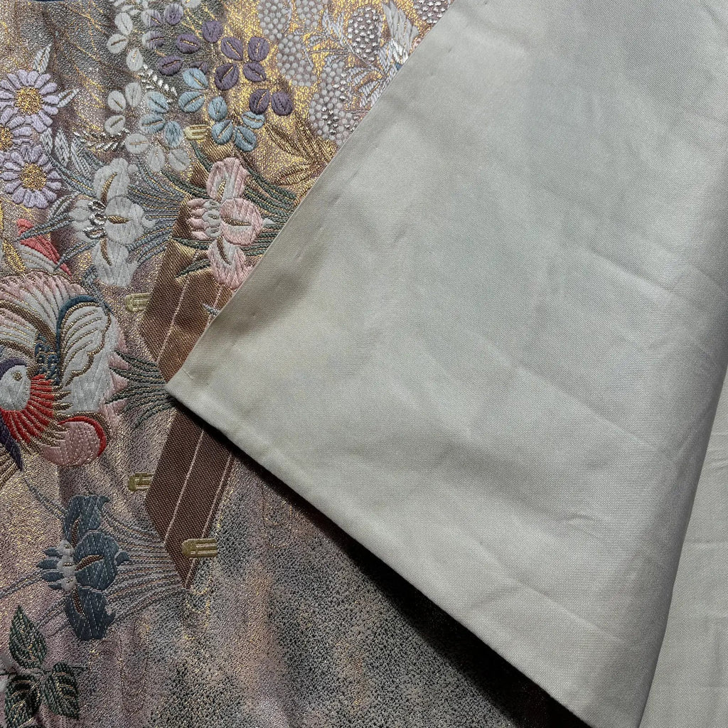 Close-up of embroidered fabric with floral patterns and a plain white fabric.