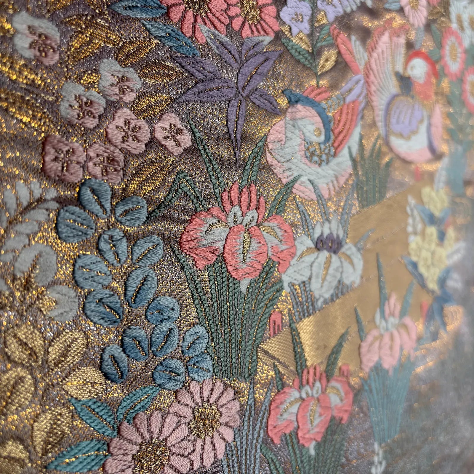 Close-up of embroidered fabric with floral and bird patterns