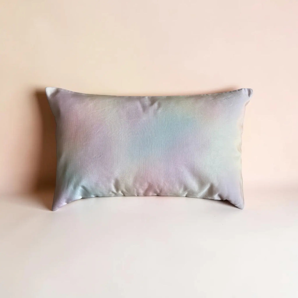 Iridescent satin cushion on a beige background