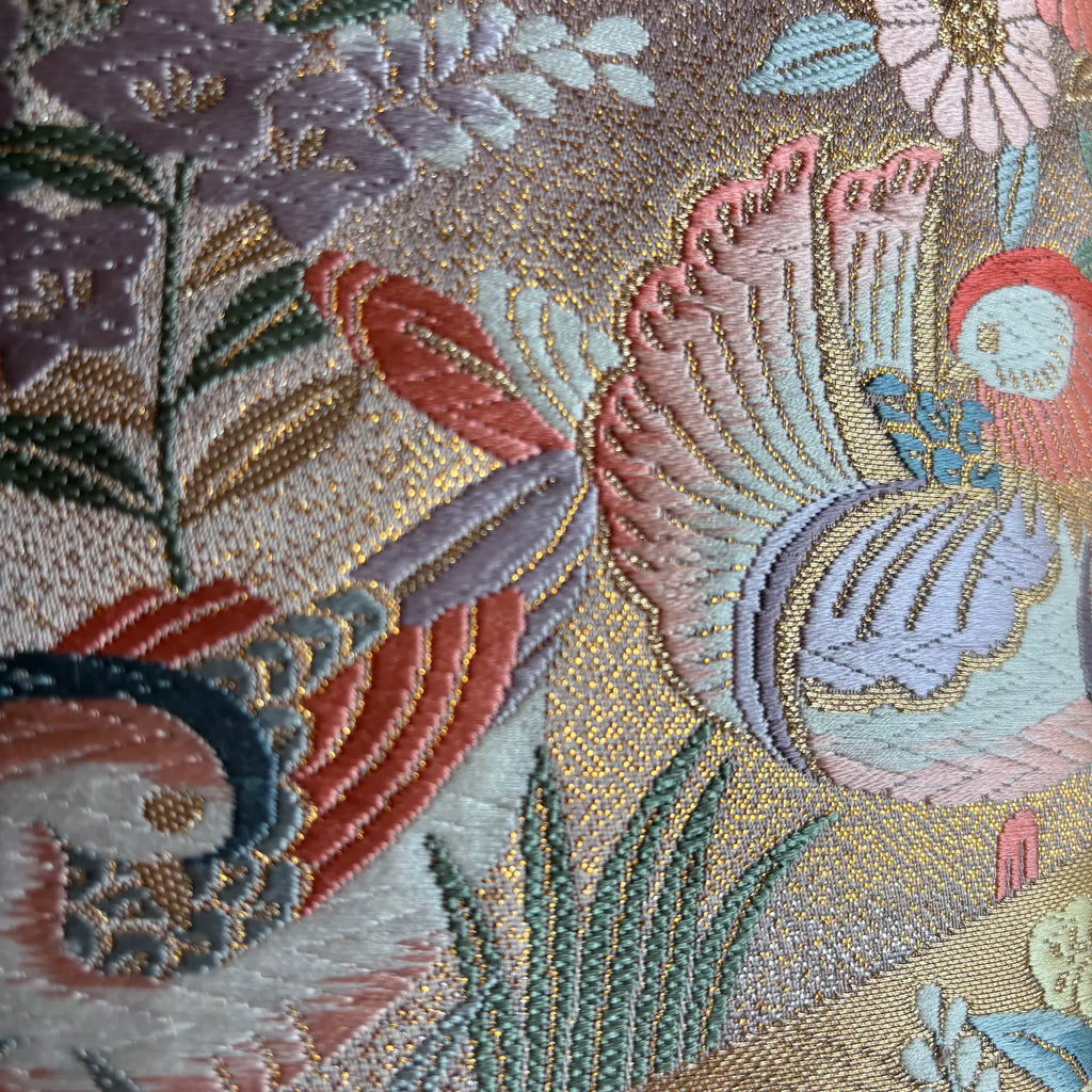 Close-up of an embroidered fabric with mandarin ducks and floral patterns