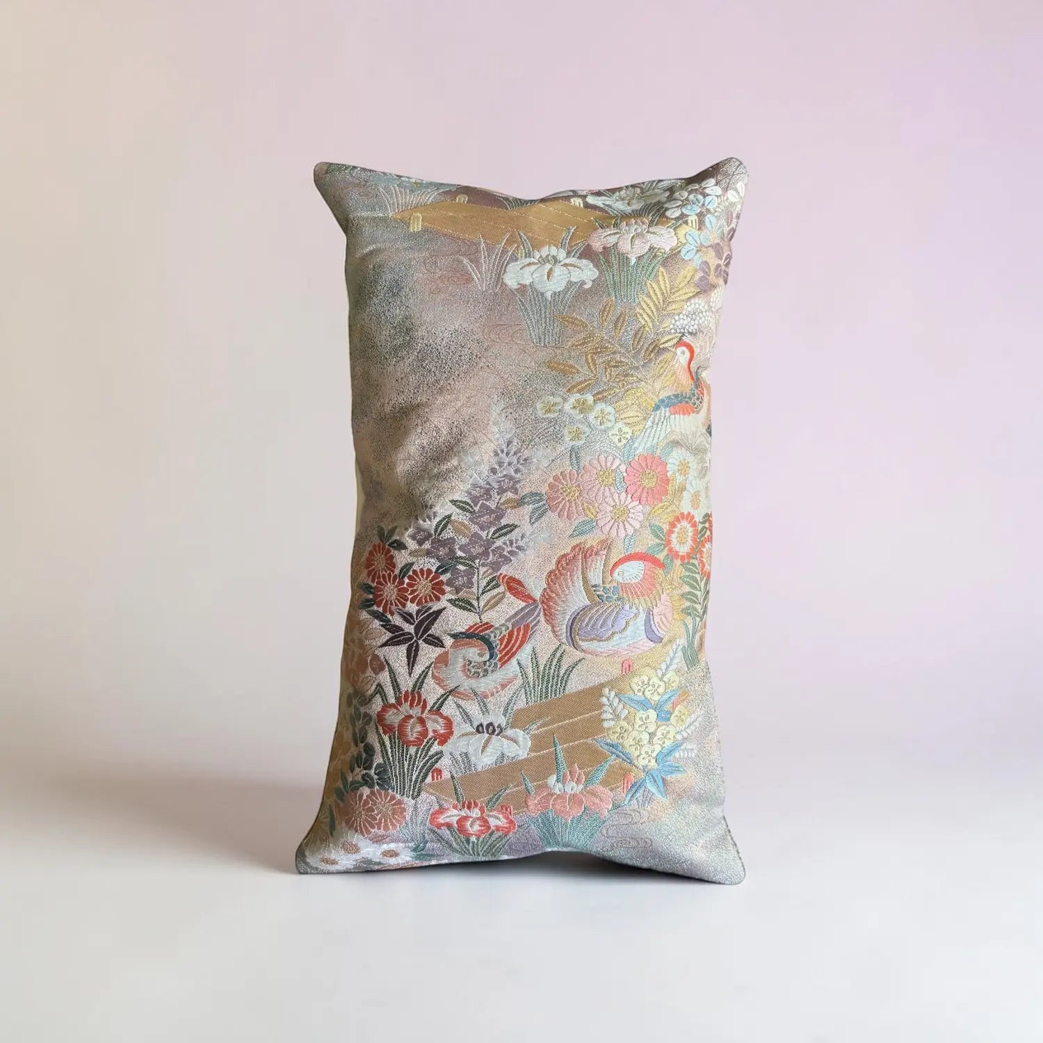 Decorative cushion with floral and duck pattern on a light pink background