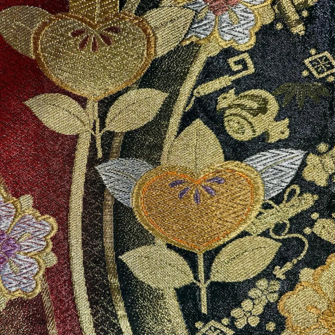 Close-up of embroidered floral pattern with leaves on a fabric background