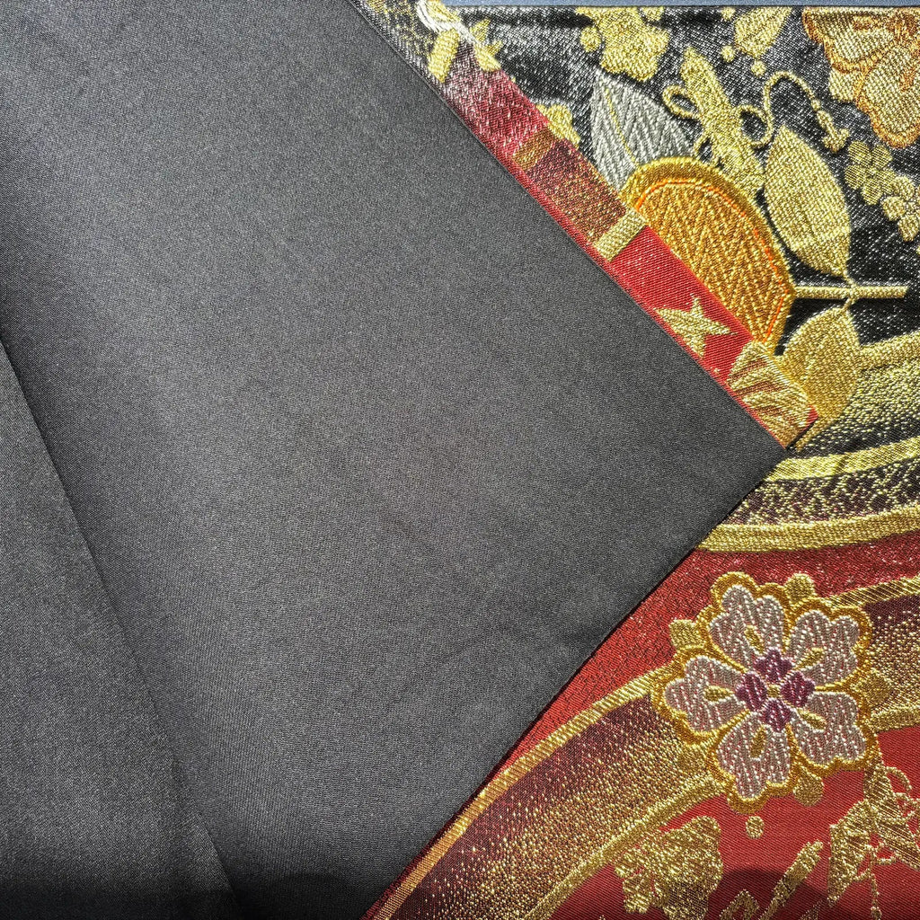 Black fabric folded and front side with floral patterns.