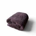 Folded purple towel on a white background