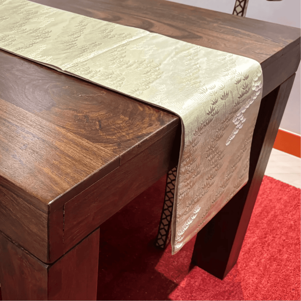 Wooden table with a decorative table runner on a red carpet