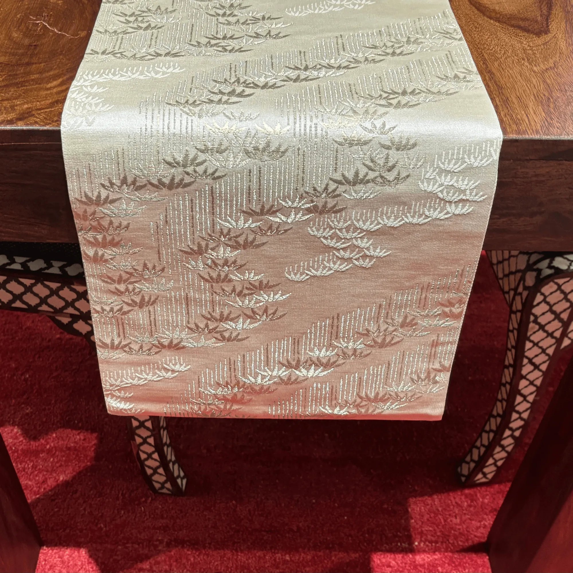 Decorative table runner with a bamboo pattern on a wooden table.
