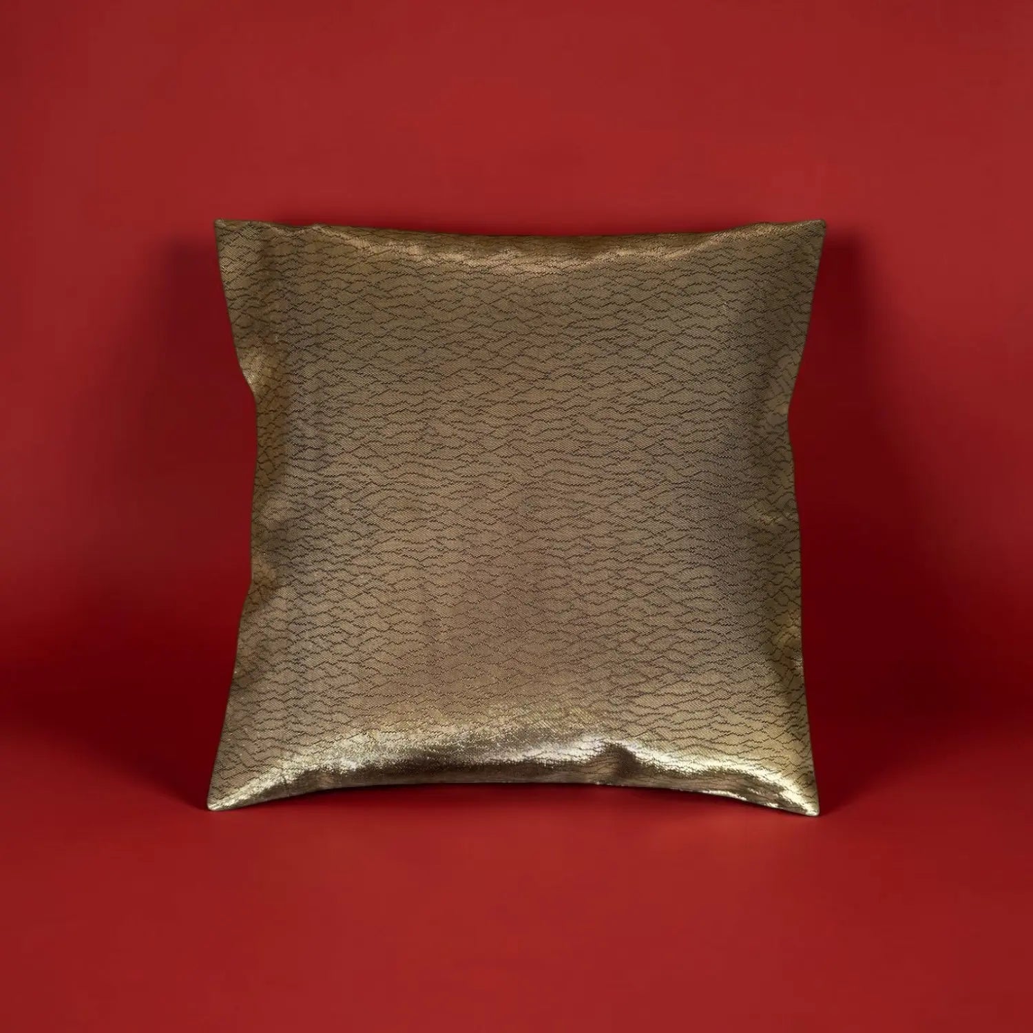 Gold textured cushion on a red background