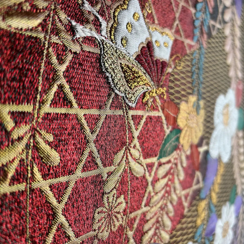 Close-up of embroidered fabric with floral patterns on a red background