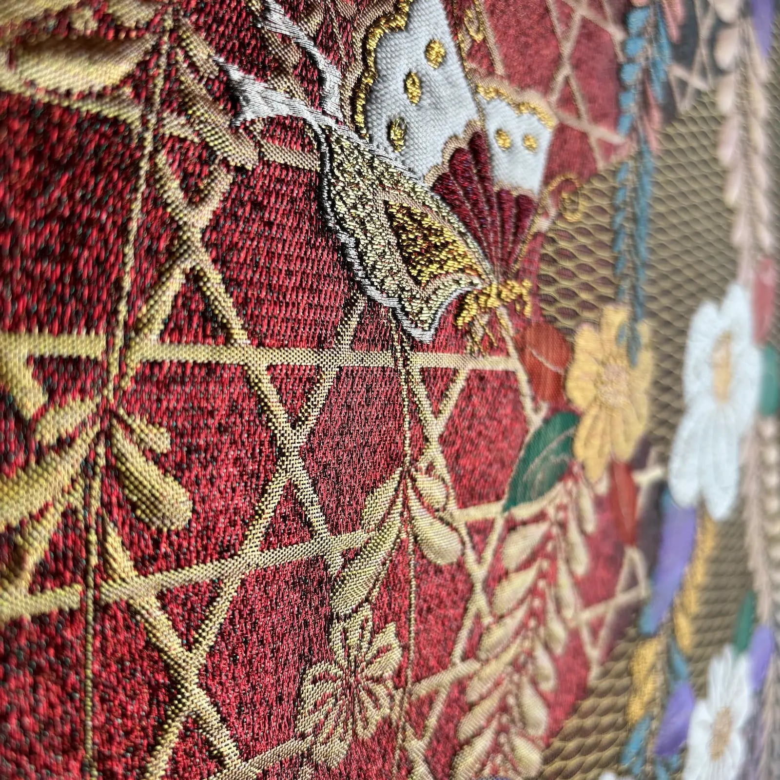 Close-up of embroidered fabric with floral patterns on a red background