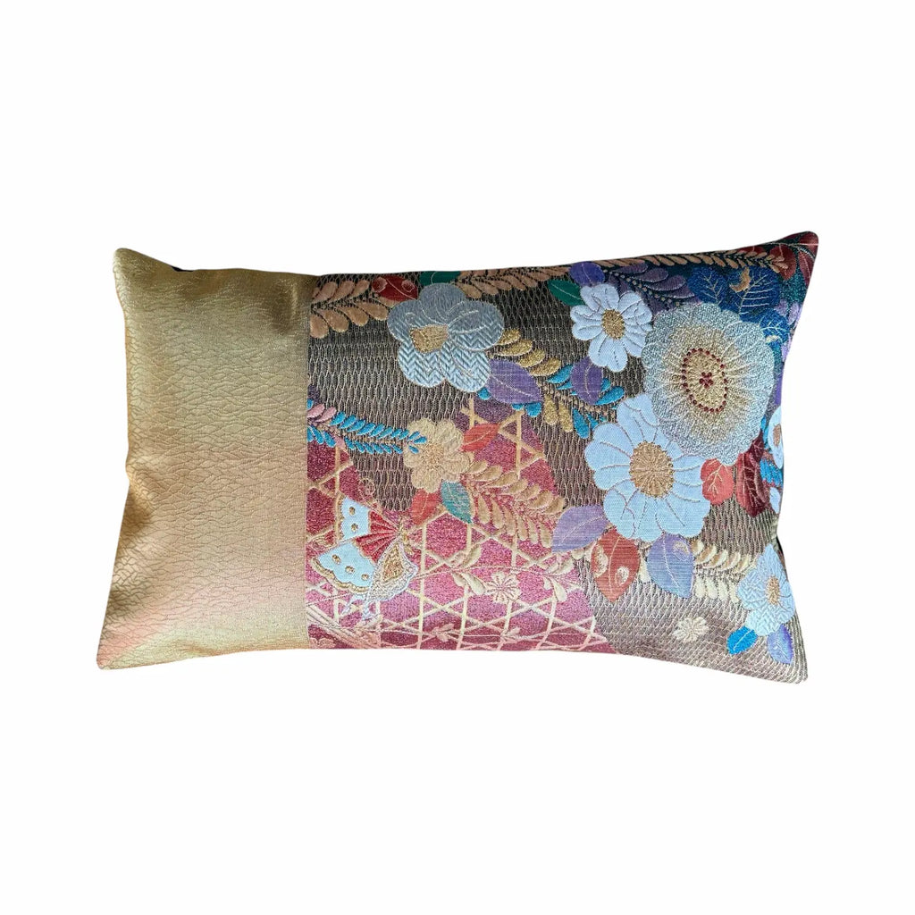 Decorative cushion with floral pattern and gold accent on a white background