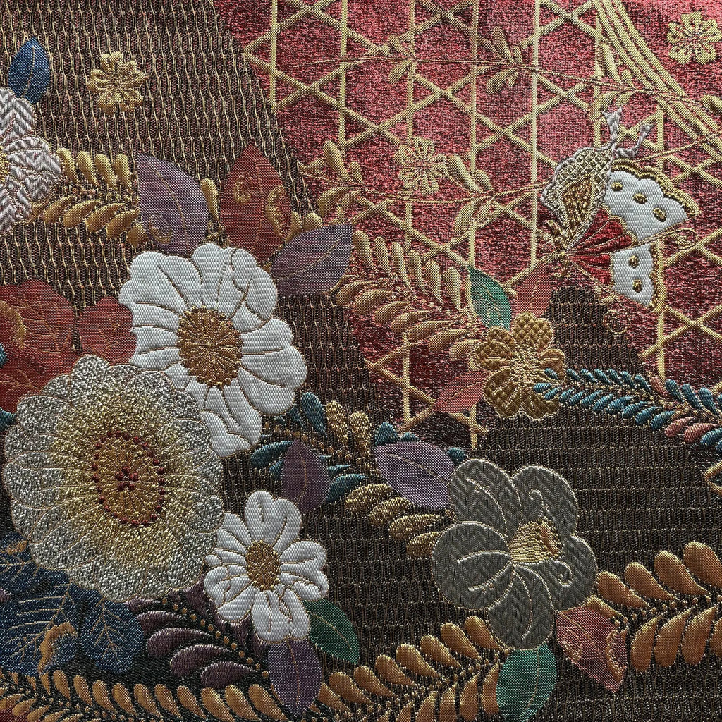 Close-up of an intricately embroidered fabric with floral and geometric patterns.