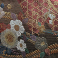 Close-up of an intricately embroidered fabric with floral and geometric patterns.