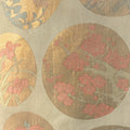 Decorative fabric with circular floral patterns in gold, pink, and beige.