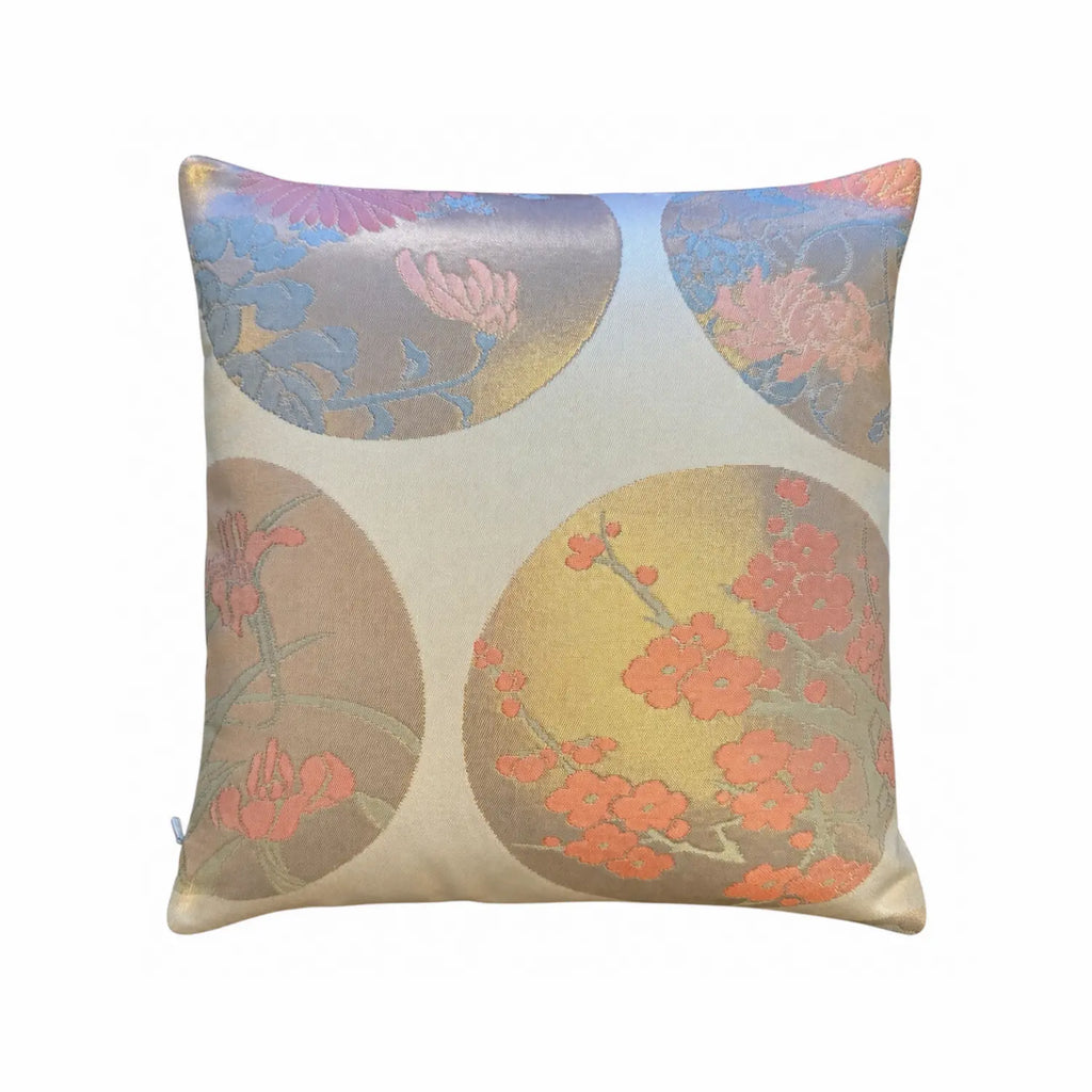 A square decorative cushion featuring a traditional Japanese-inspired damask pattern with circular floral motifs in muted gold and pink on a pink background.