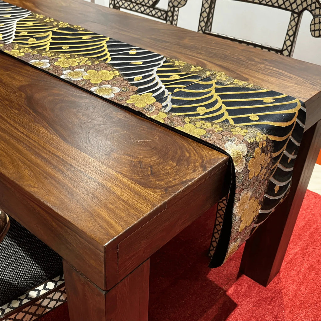 Wooden table with a decorative table runner featuring floral patterns.