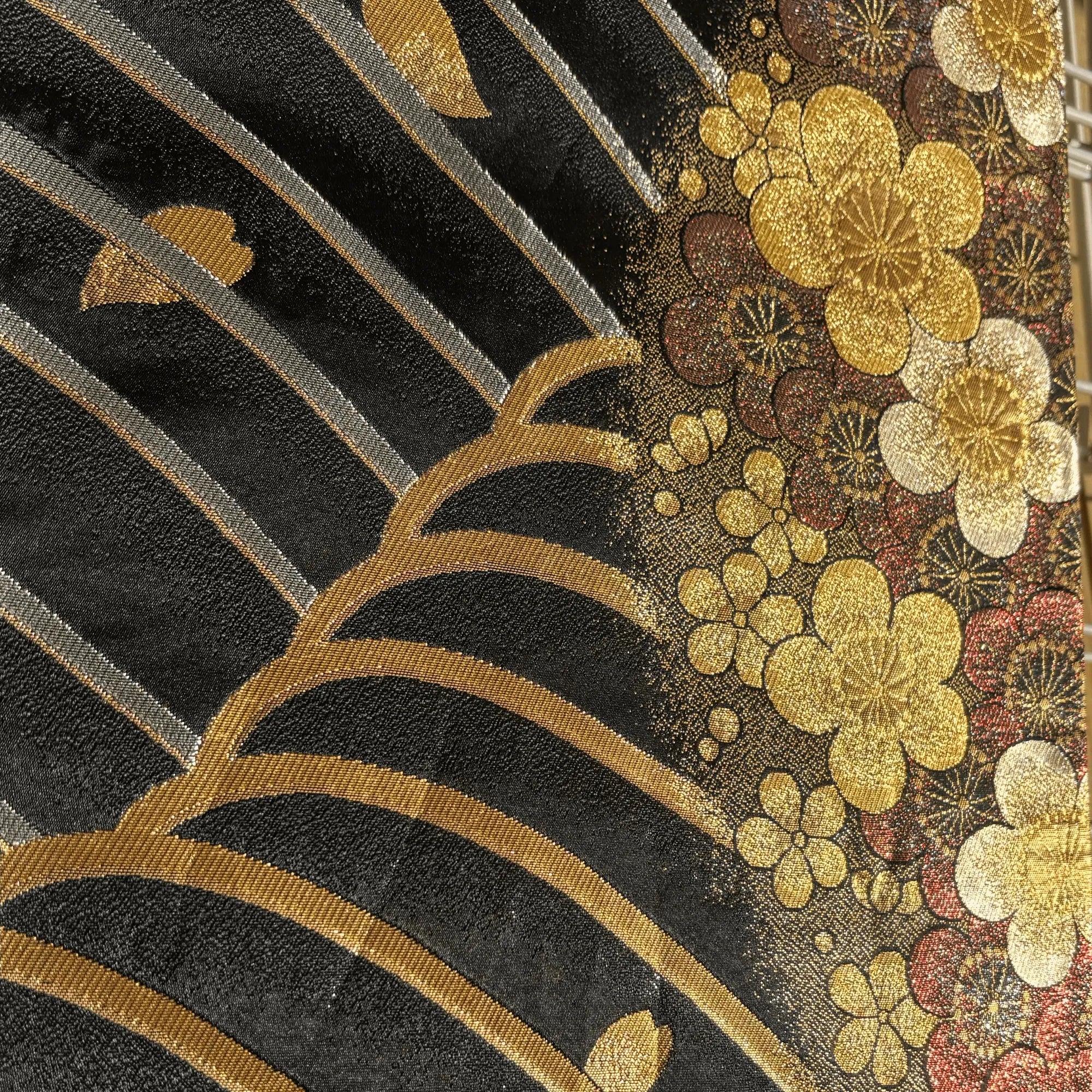 Close-up of embroidered silk with floral patterns on a black background