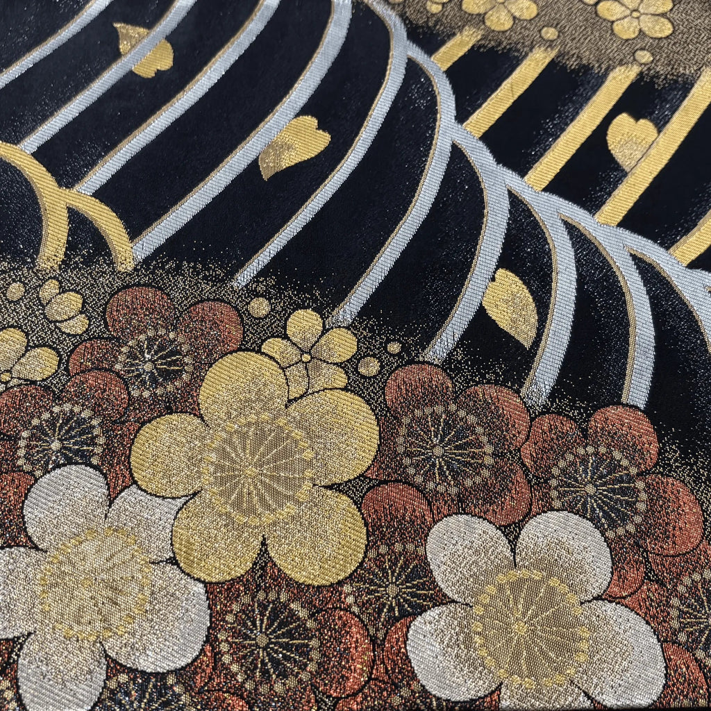 Decorative fabric with floral patterns and metallic accents on a dark background