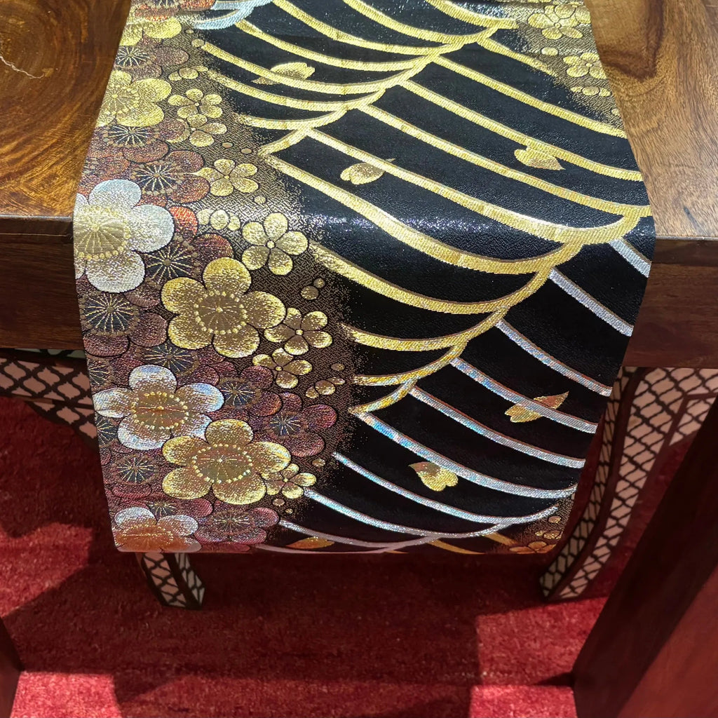 Decorative table runner with floral and wave pattern on a wooden surface