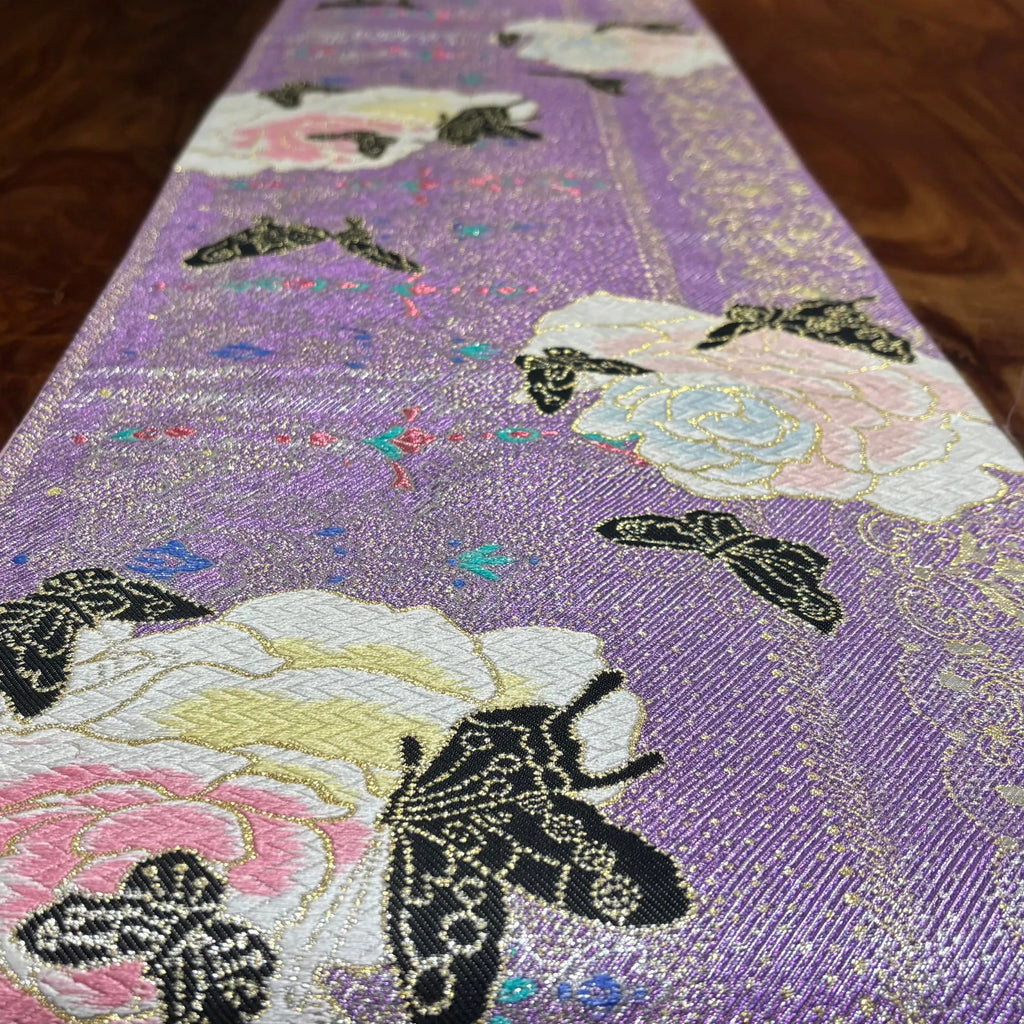Decorative fabric with embroidered butterflies and flowers on a purple background