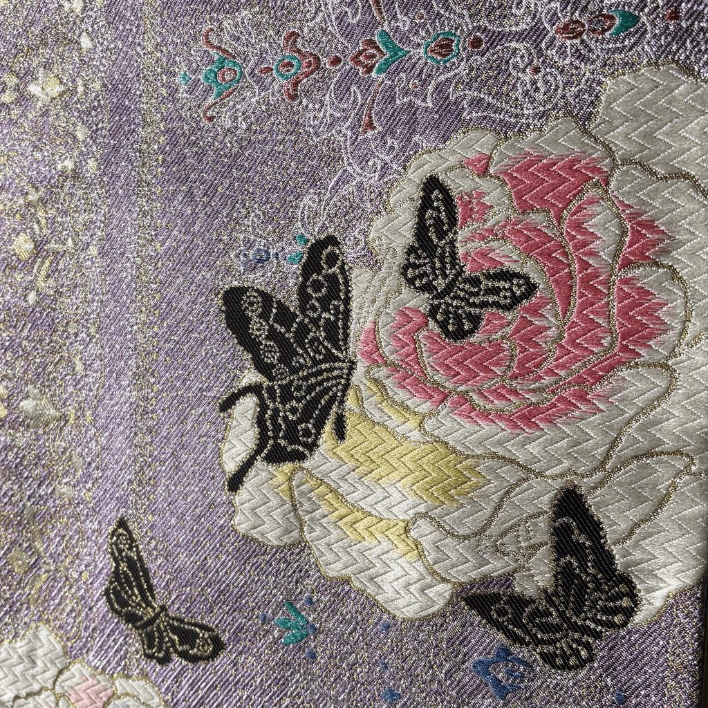 Embroidered fabric with a floral design and butterflies on a textured background