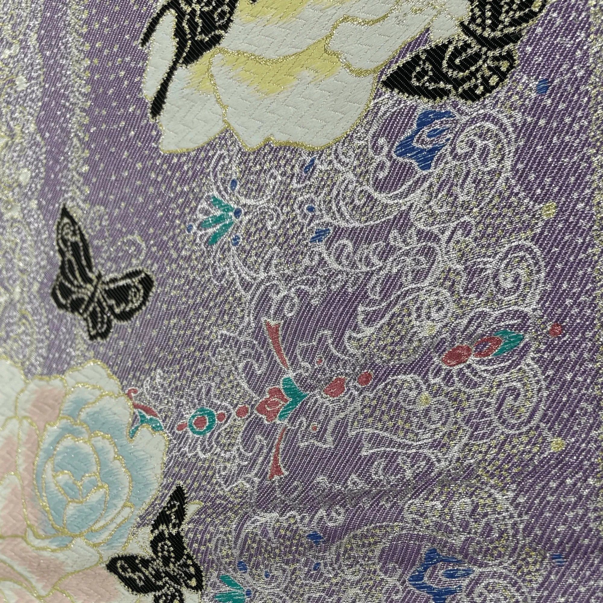 Close-up of a fabric with floral and butterfly patterns on a purple background
