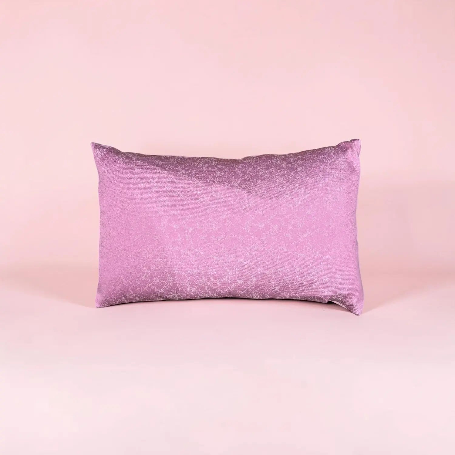 Purple satin cushion on a pink background