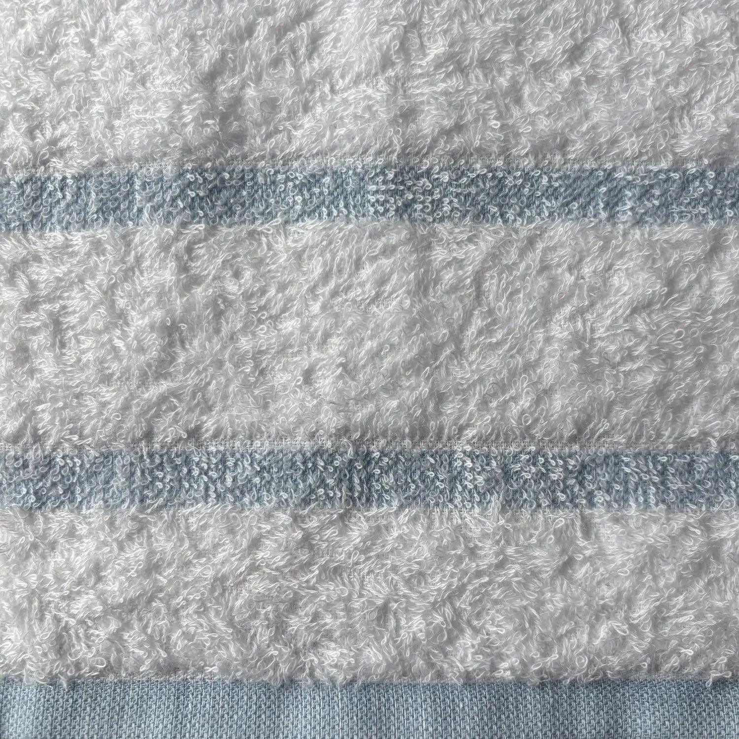 Close-up of textured fabric with horizontal stripes in blue and white.