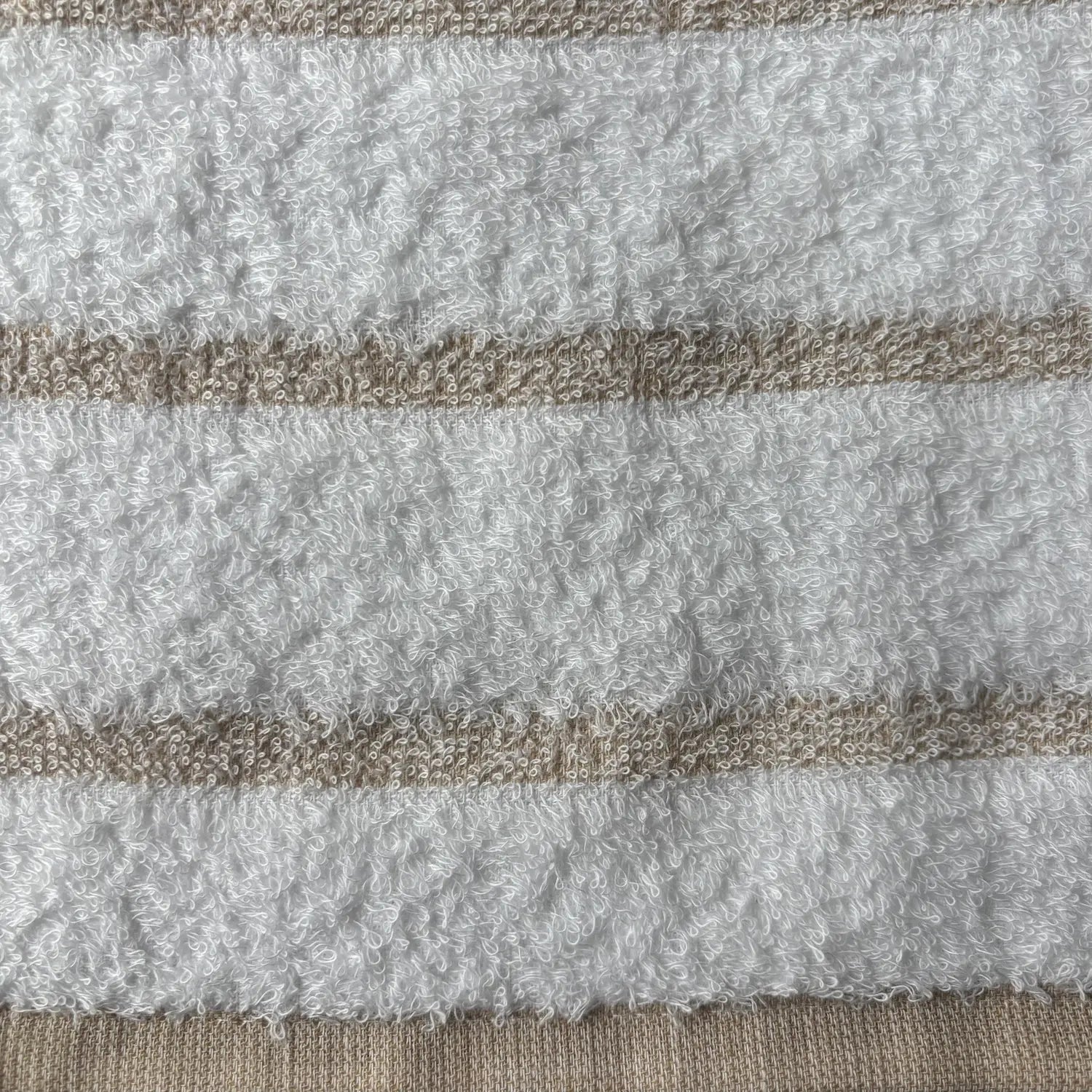 Close-up of textured fabric with horizontal stripes in beige and white.