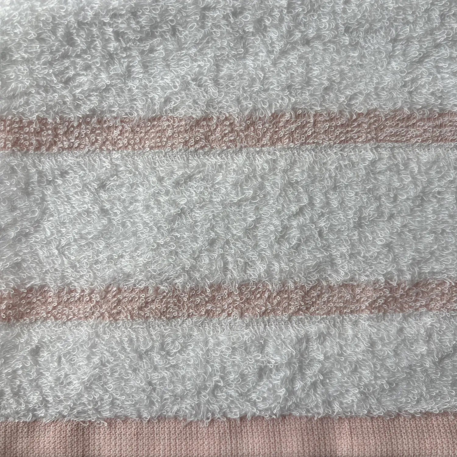 Close-up of a textured fabric with horizontal stripes in pink and white.