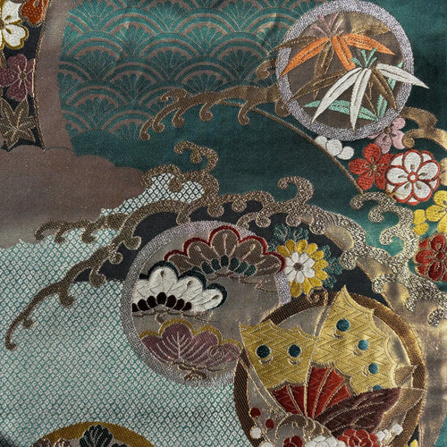 Close-up of intricately embroidered fabric with floral and leaf patterns.