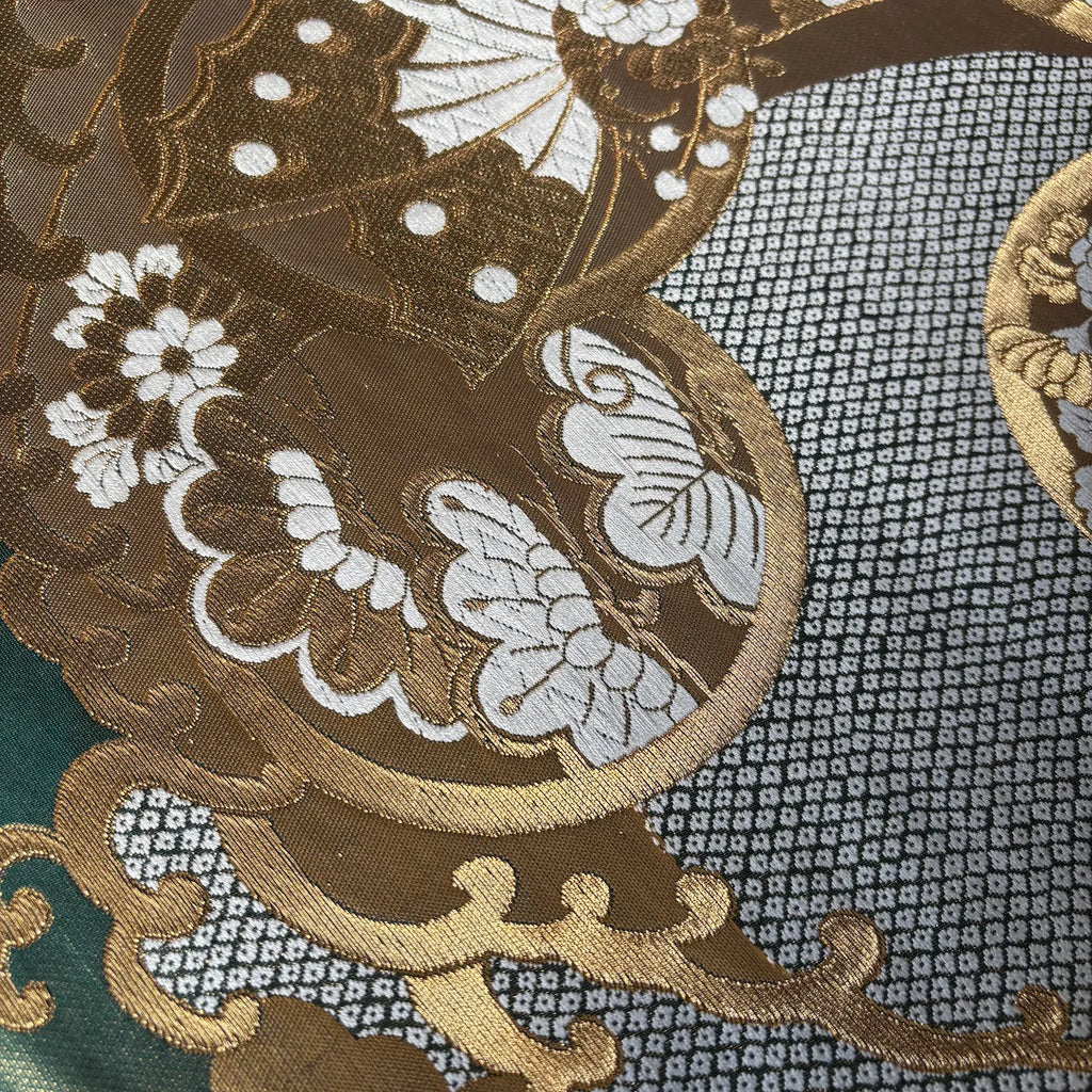 Close-up of intricate embroidered fabric with floral and butterfly designs.